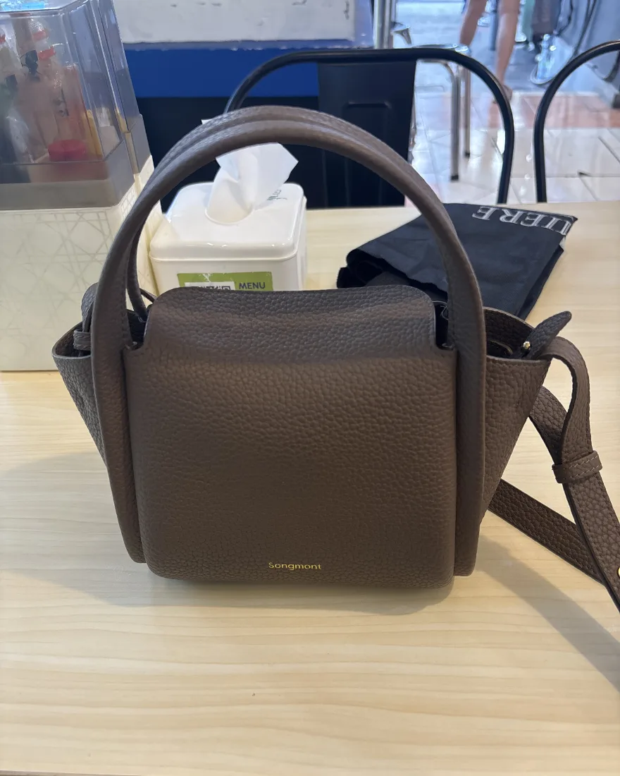 The original phone photo: the handbag on a cluttered cafe table